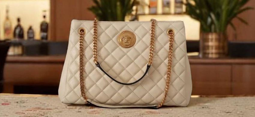 
Versace light handbag with gold-colored chains.